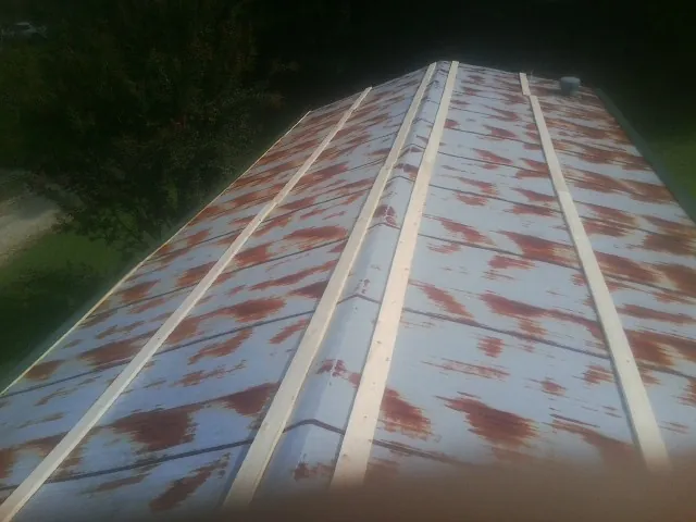 Rusted metal roof panels with new wood purlins before replacement — Storm Damage Roof Repair in Island Park by Roofing Brothers