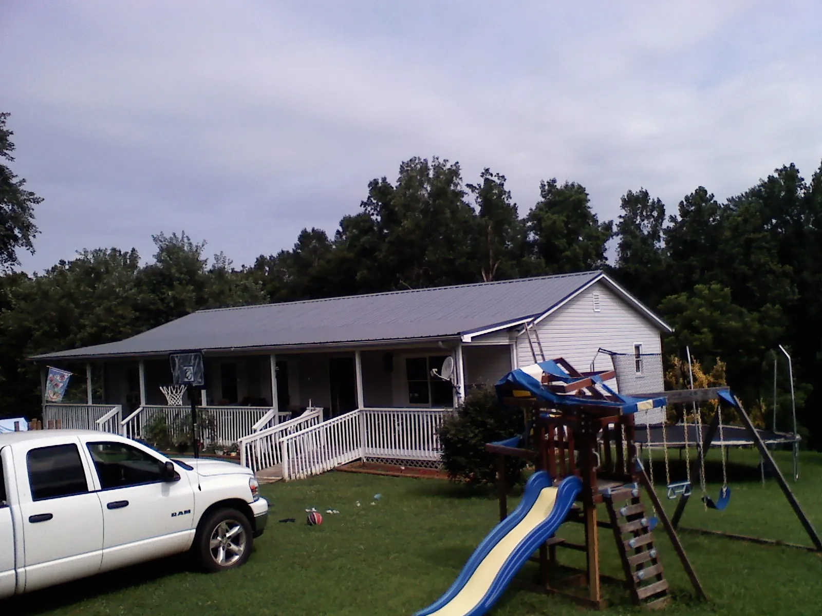 Dark metal roof on a country home with a full length front porch in Island Park