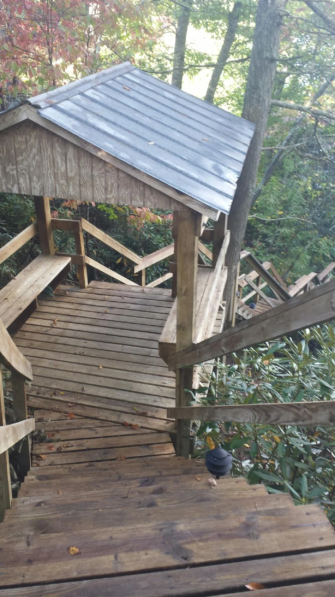 Metal roofed shelter over wooden steps on a wooded walkway — Skylight Repair & Installation work by our crew in Island Park